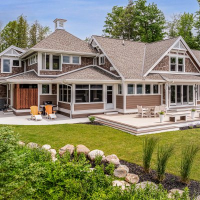 exterior view from lake: outdoor shower, screened porch, library